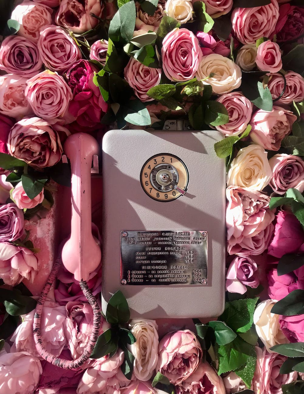 an old telephone with pink roses